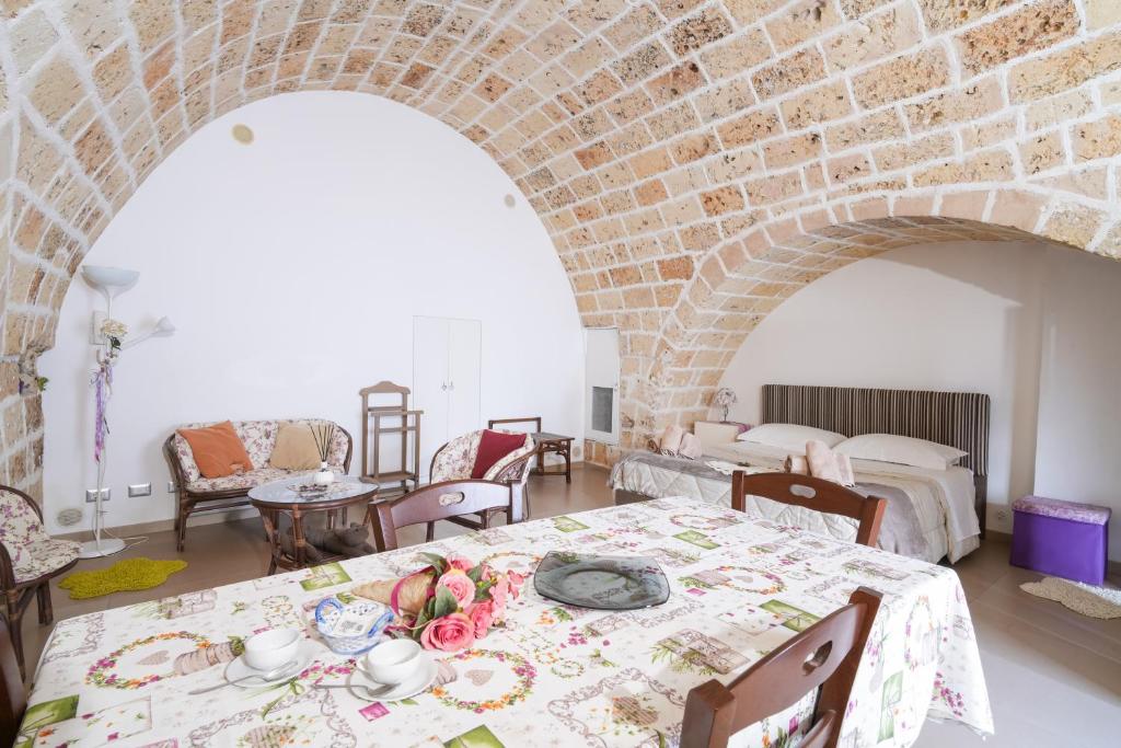 una stanza con due tavoli e un muro di mattoni di Sweet Home Arco Porta Luce a Galatina