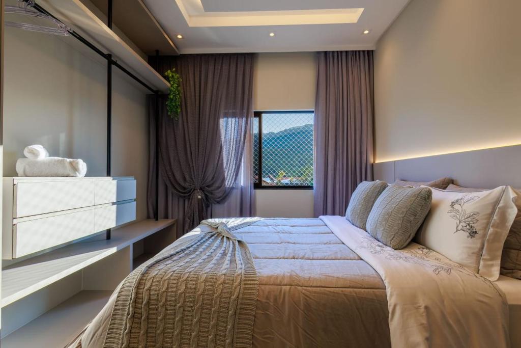 a bedroom with a large bed and a window at Apartamento 401 wiithhoeftf in Pomerode
