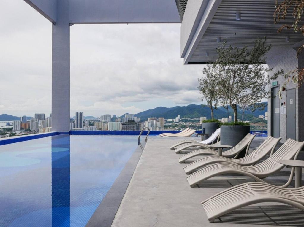 a row of lounge chairs sitting next to a swimming pool at 22Macalisterz Georgetown Studio in George Town