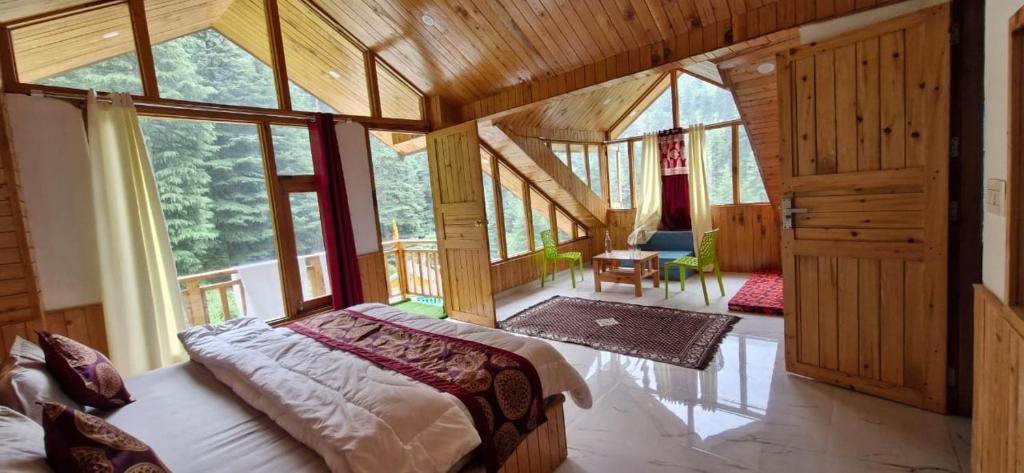 a bedroom with a bed in a room with windows at woodstock villa & cafe in Jibhi