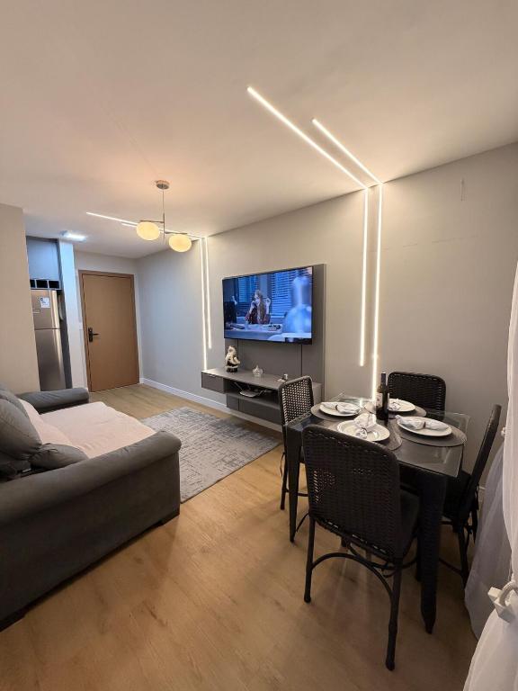 a living room with a couch and a table with chairs at Ponta Negra Apartment in Manaus