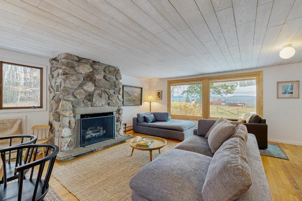 a living room with a couch and a stone fireplace at The Prospect House in Bethlehem