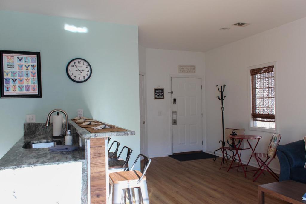 a kitchen and living room with a clock on the wall at The Jr. Suite at 205 Royal Poste Rd. in Sunset Beach