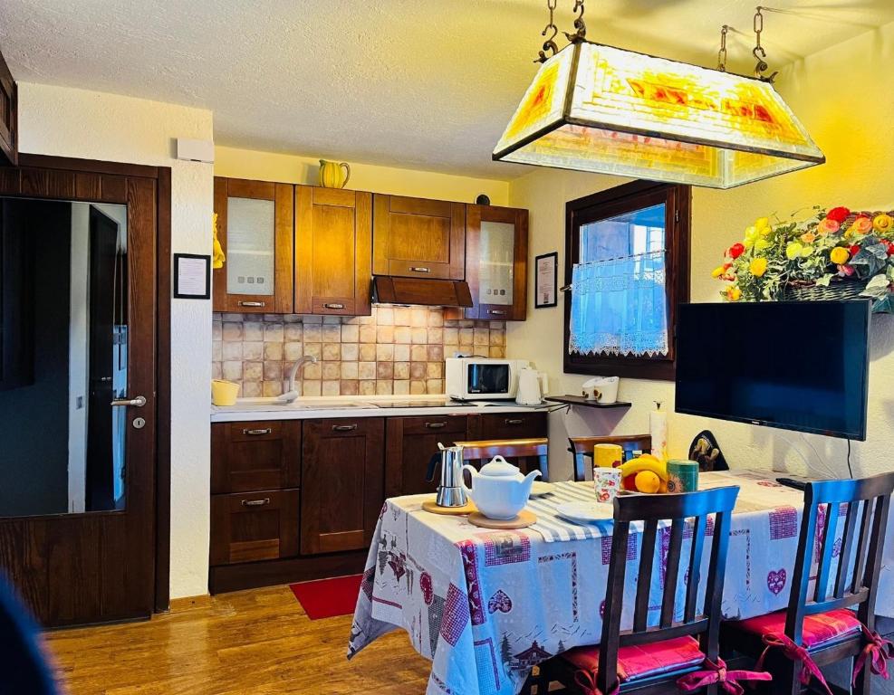 een keuken met een tafel en twee stoelen en een keuken met een tafel bij GuestHost - Petite Fleur - Cozy La Thuile Flat in La Thuile