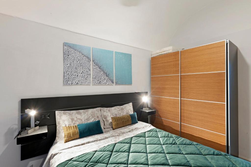 een slaapkamer met een groot bed en houten kasten bij Magia e Luce in Sanremo