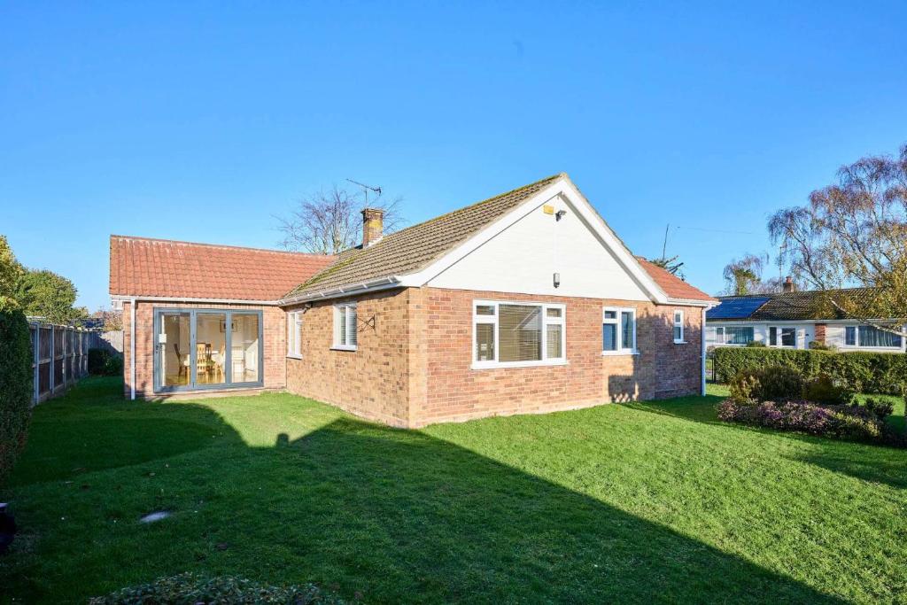 une grande maison en briques avec une cour d'herbe dans l'établissement Host & Stay - WillowStay, à Martham