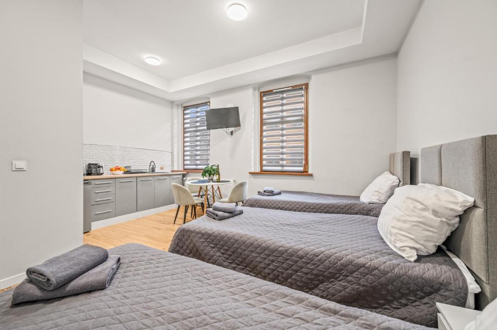 a bedroom with two beds and a kitchen in it at Central Platinum Apartments 2 Studio z aneksem kuchennym 3 łóżka in Rybnik