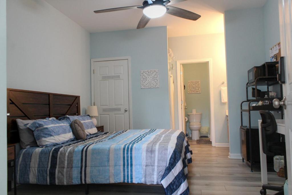 a bedroom with a bed and a ceiling fan at Beach Bungalow by Coastal Concierge in Sunset Beach