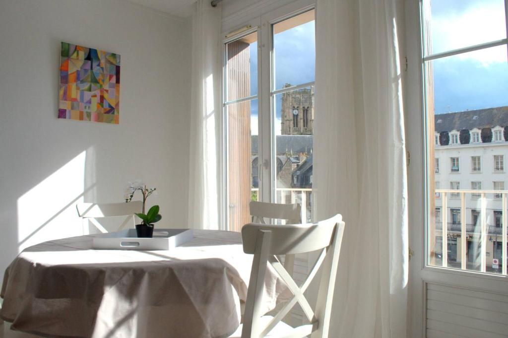 een witte tafel en stoelen in een kamer met een raam bij Les Cerfs Volants 2 à 4 pers in Dieppe