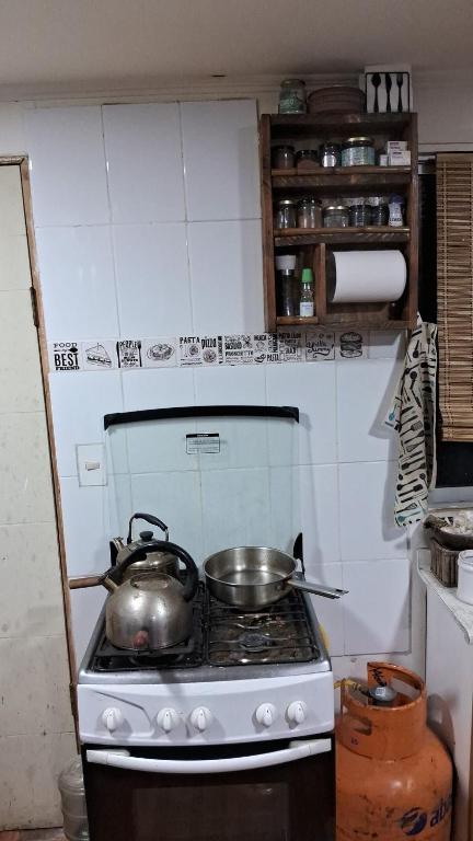 a stove with two pots and pans on top of it at Cabaña con tinaja para 6 personas in San Clemente