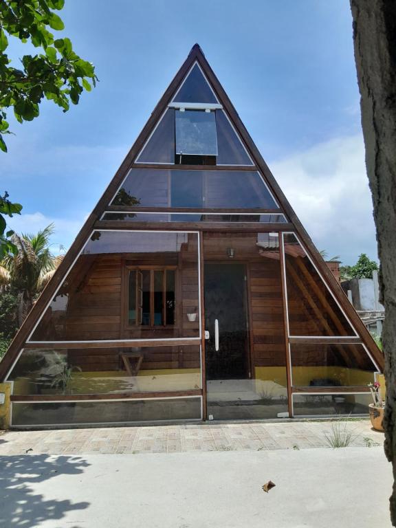 una casa con un tetto triangolare con una porta di chalé alpino a Saquarema