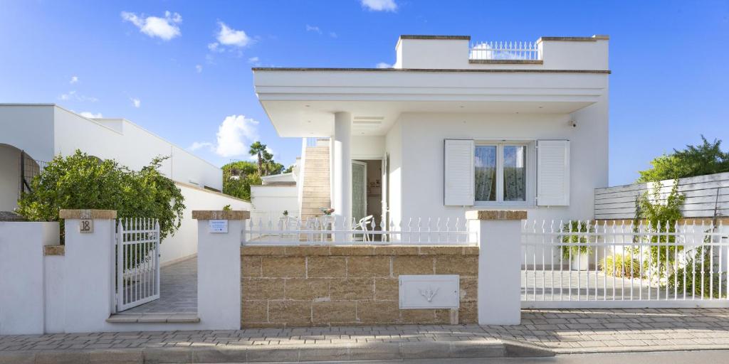 Biały dom z białym płotem w obiekcie A Pochi Metri Dal Mare Seminterrato w mieście Marina di Mancaversa