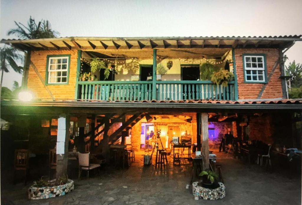 a house with a balcony with a table and chairs at Pouso Sagarana in Mariana