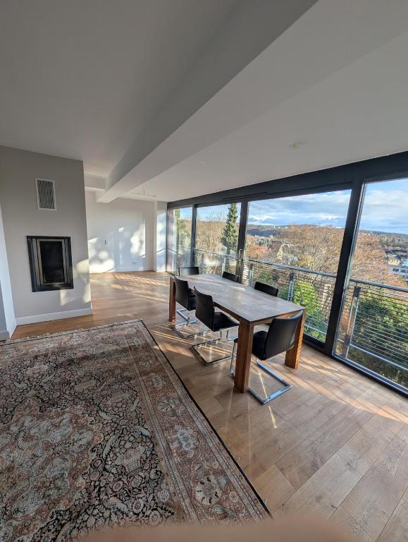 a dining room with a table and chairs and large windows at Large city apartment with beautiful views in Marburg an der Lahn