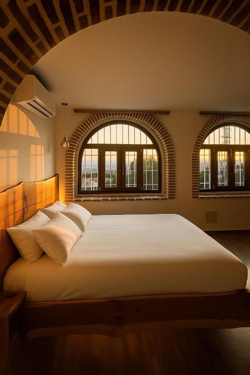a bedroom with a large bed with two windows at Los Siete Arcos in Granada