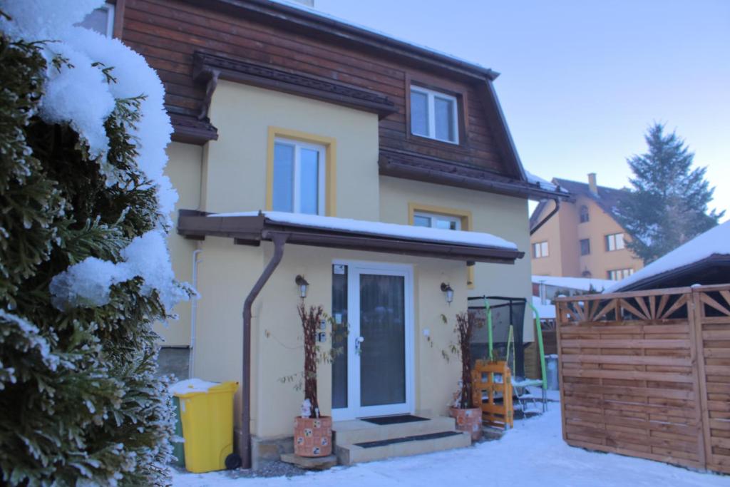 a house with snow on the front of it at Penzión u Jurka Zuberec in Zuberec