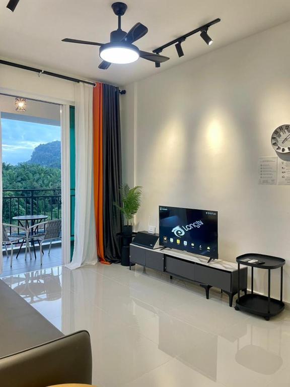 a living room with a flat screen tv on a wall at Jhomestay2 in Sandakan