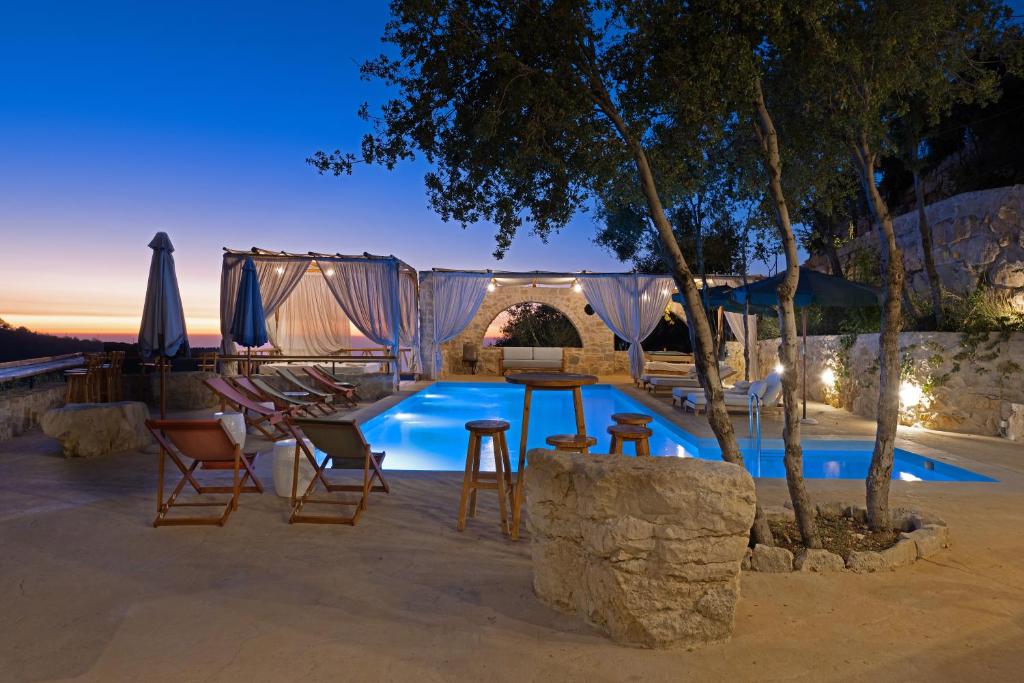 a swimming pool with a table and chairs next to it at Casadar Guesthouse in Ash Shi‘b