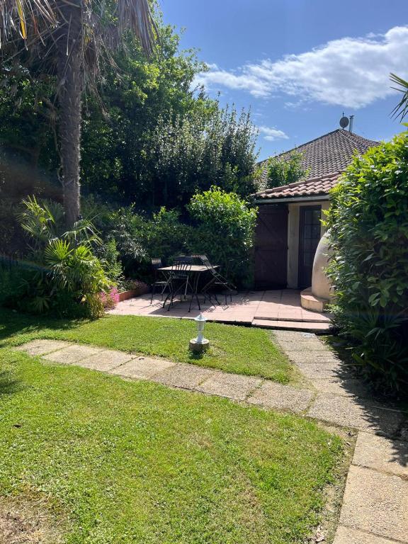 a garden with a picnic table and a patio at renaissance larmane in Eugénie-les-Bains