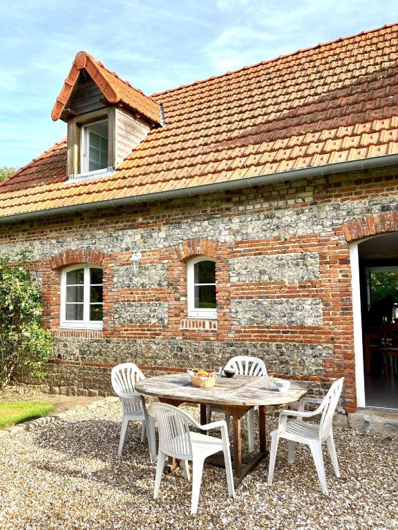 a table and chairs in front of a brick building at CÔTE MER in Quiberville