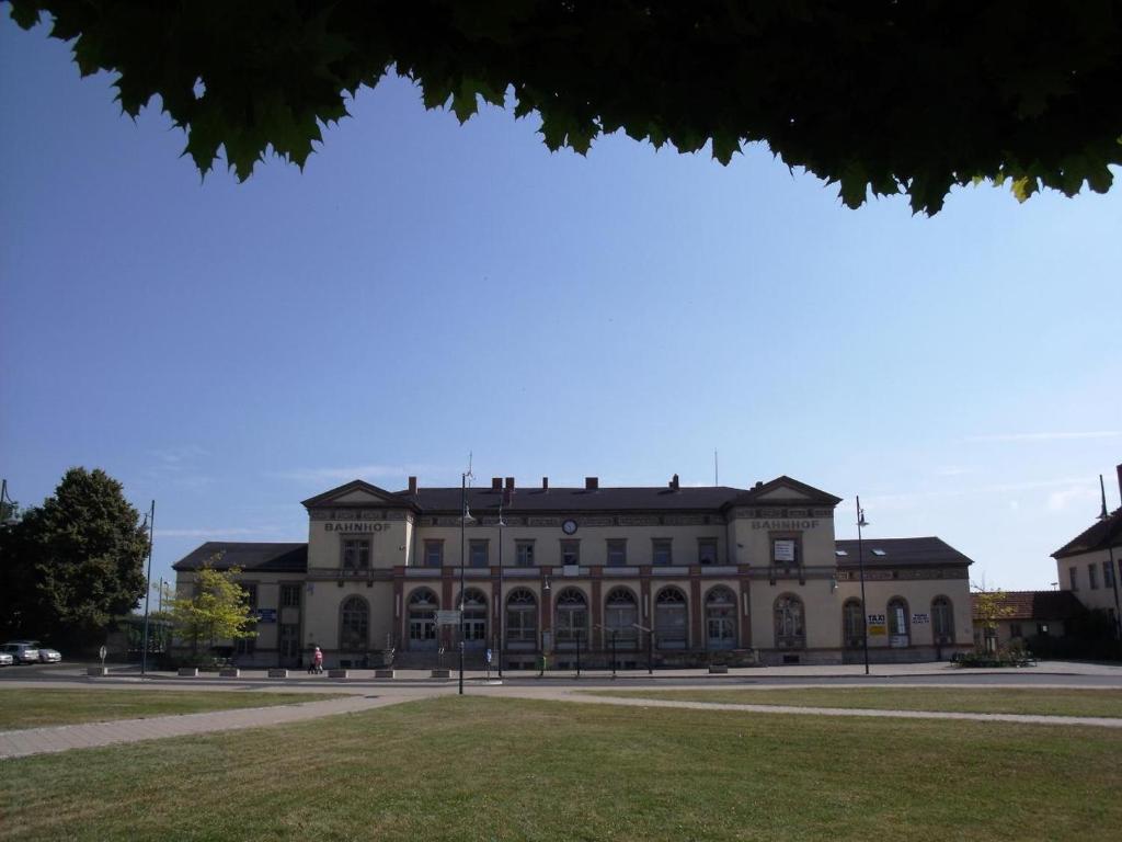 Pension am Bahnhof Mühlhausen في مولهاوزن: مبنى كبير في وسط حديقة