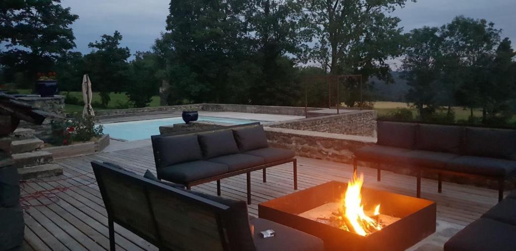 a backyard with a fire pit and a pool at La FRAMBOISINE in Les Granges