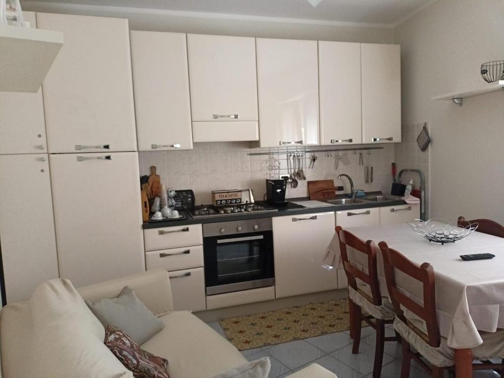 a kitchen with white cabinets and a table with a dining room at Casa Canale in Gesualdo