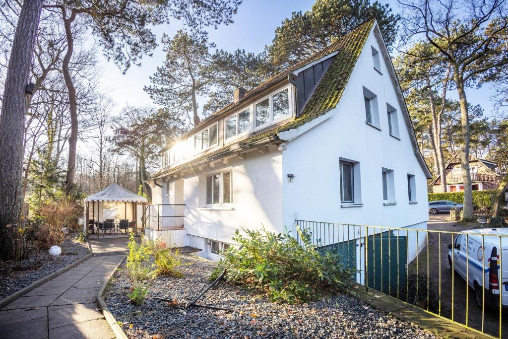 a white house with a green fence at Ferienhaus Sandstrand in Timmendorfer Strand