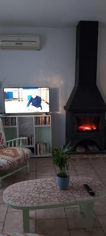 La bonne franquette في Saint-Pompont: غرفة معيشة مع موقد وأريكة