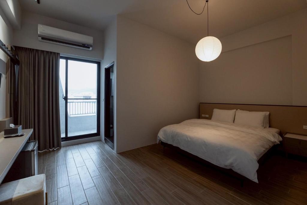 ein Schlafzimmer mit einem Bett und einem großen Fenster in der Unterkunft 天盛安家民宿台東一館 in Taitung