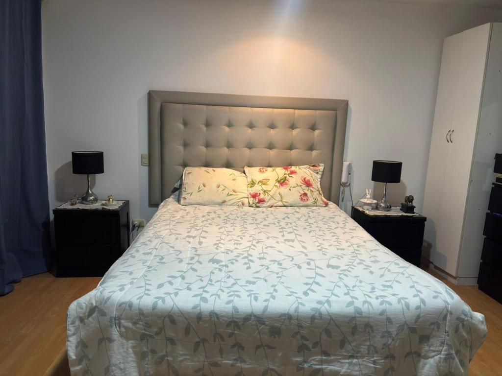 Casa Portada del Sol في La Molina: غرفة نوم بها سرير كبير وطاولتين جانبيتين