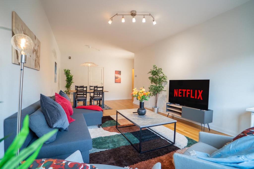 a living room with a blue couch and a tv at Large Central 2BR - Scandinavian Design - Balcony in Gothenburg