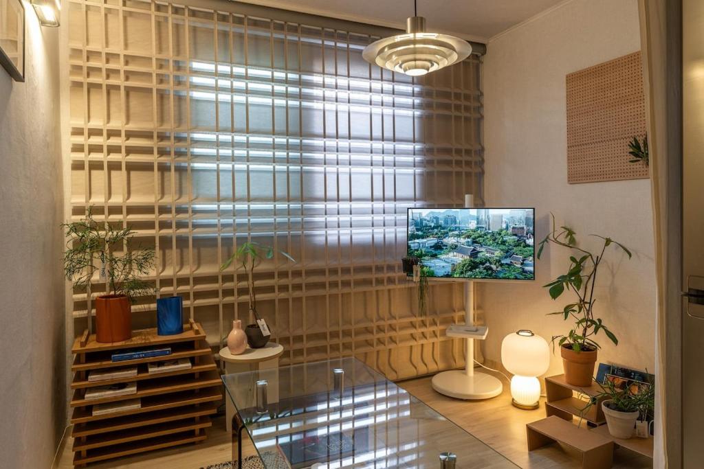 een woonkamer met een glazen tafel voor een raam bij Sogonhanzip in Seoul