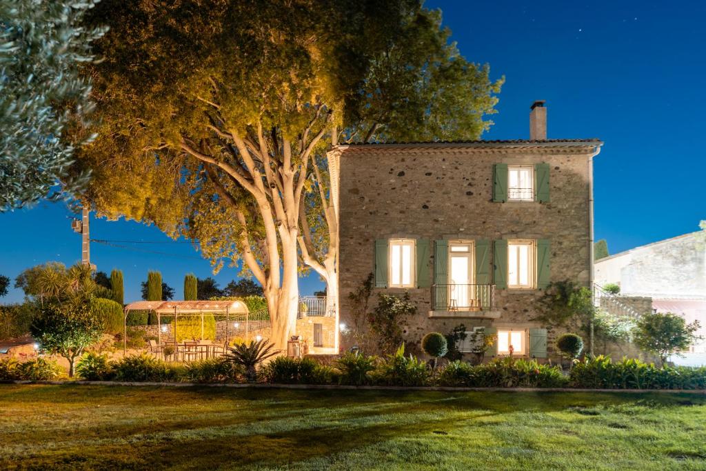 an old stone house with a tree in front of it at La Mouline sublime domaine privatif avec piscine à Pézenas in Pézenas