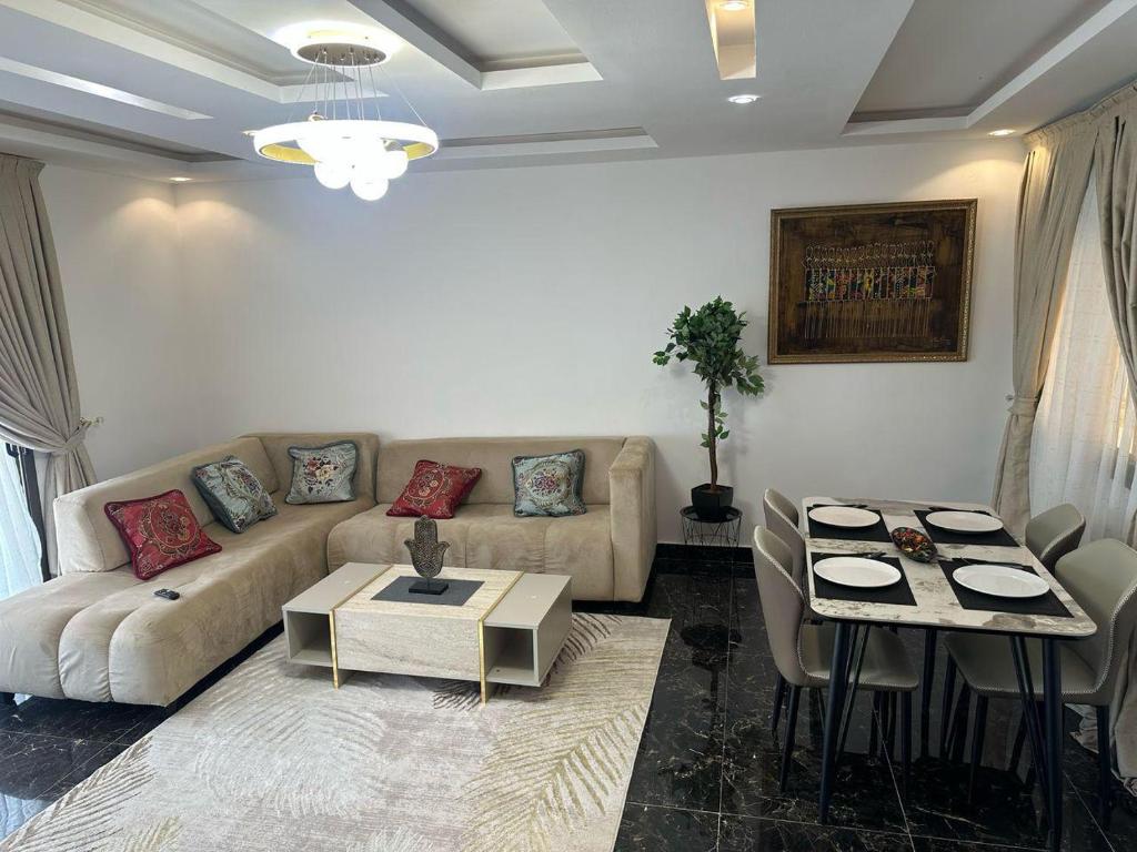 Résidence Diba في داكار: غرفة معيشة بها أريكة وطاولة