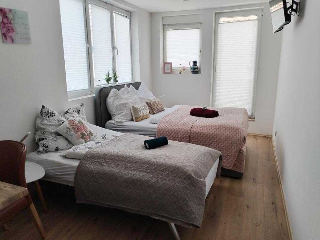 two beds and a couch in a room with windows at Hotel Silonce Bilstein in Lennestadt