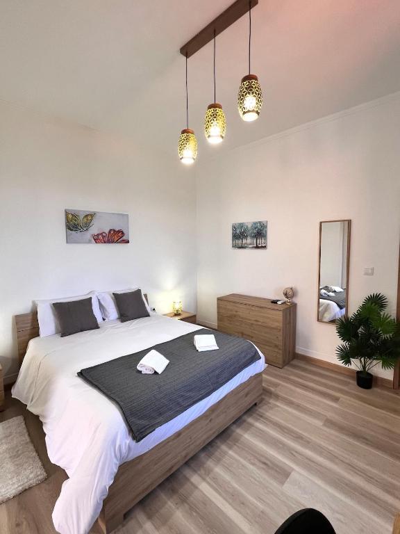 - une chambre avec un grand lit et deux lumières dans l'établissement Bravas House 1, à Tábua