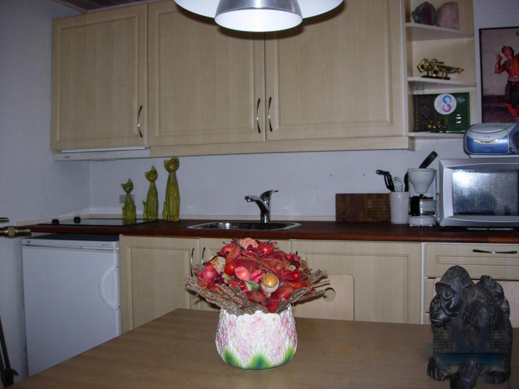 a kitchen with a vase of fruit on a table at Travel back in time in Nyord