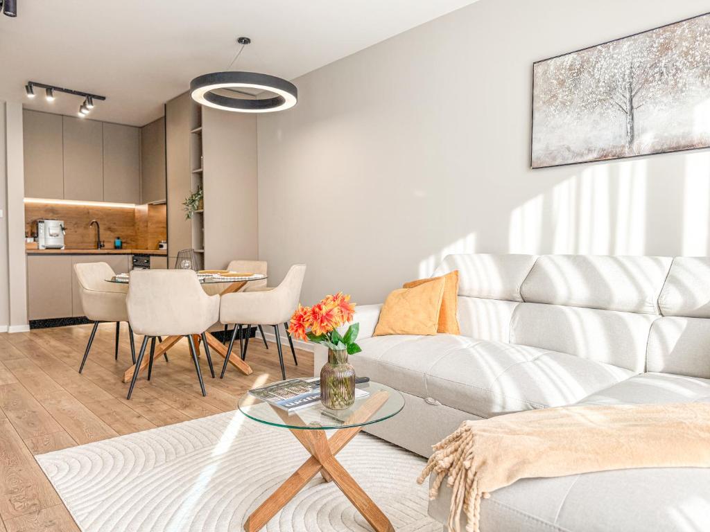 un soggiorno con un divano bianco e un tavolo di 1BR Apartment in a Modern Complex a Plovdiv