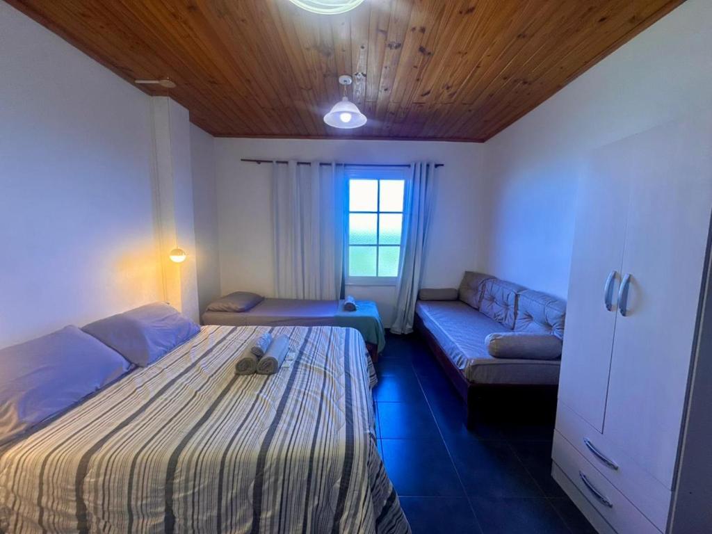 a small bedroom with a bed and a couch at Mandua in Puerto Iguazú
