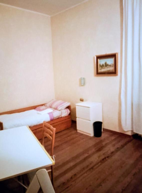 a small room with two beds and a table at A un passo dal centro gli orsetti del duomo in Piacenza