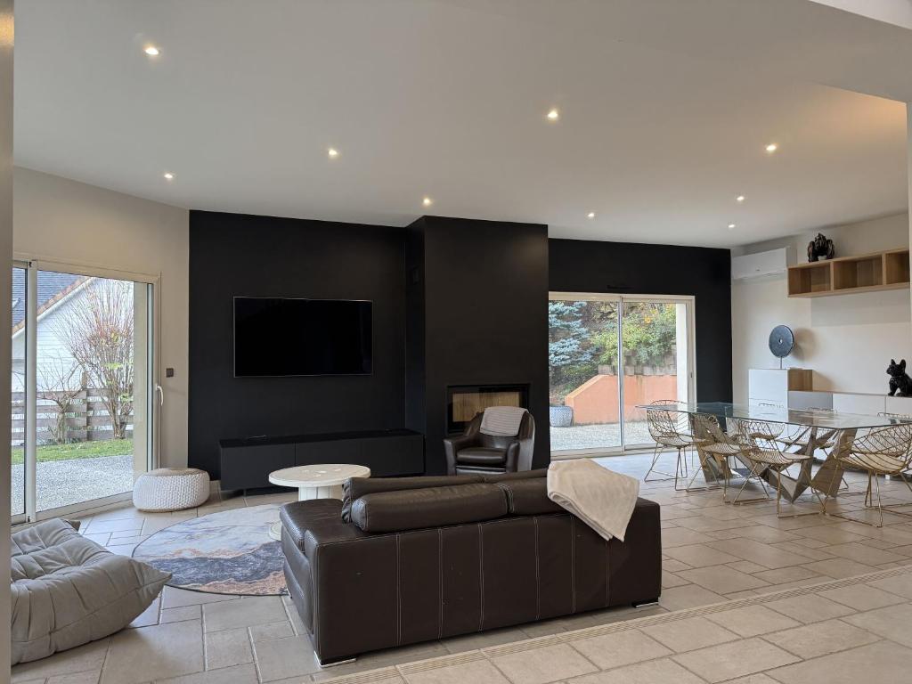 a living room with a couch and a table at Villa Belvédère - Jacuzzi, Billard, Garage & Vue in Le Mans