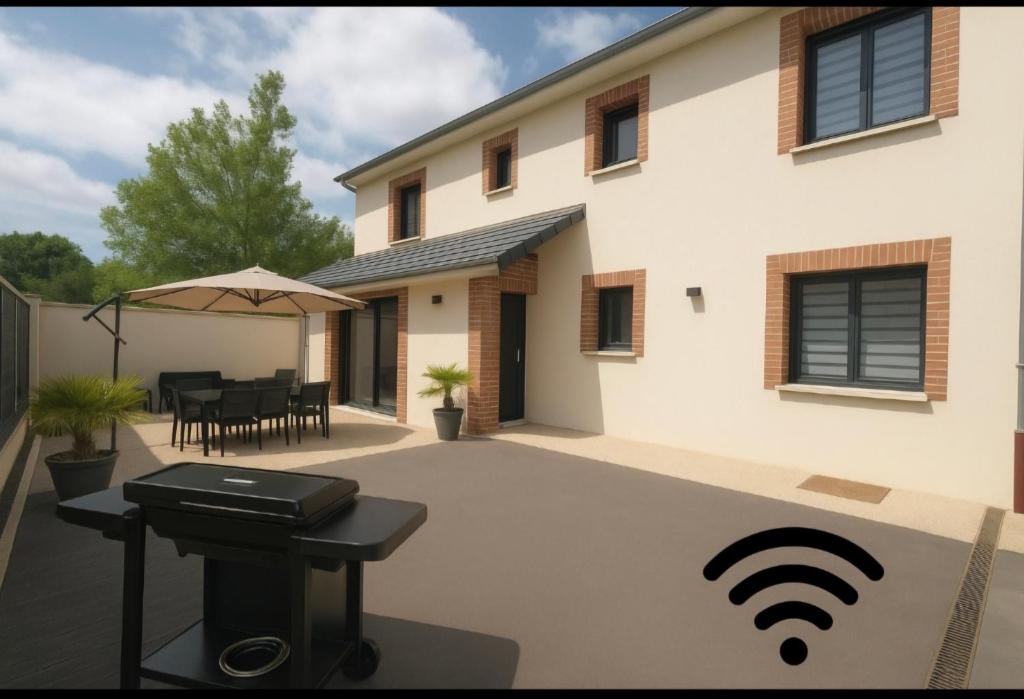 ein Haus mit Terrasse, Grill und Grillrost in der Unterkunft Gîte le Cubry in Moussy