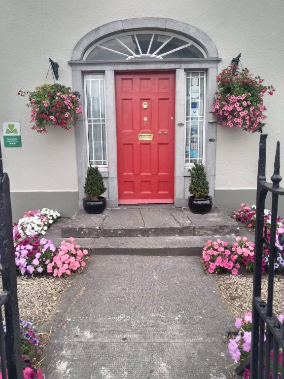 a red front door of a house with flowers at Townsend House Guest House in Birr