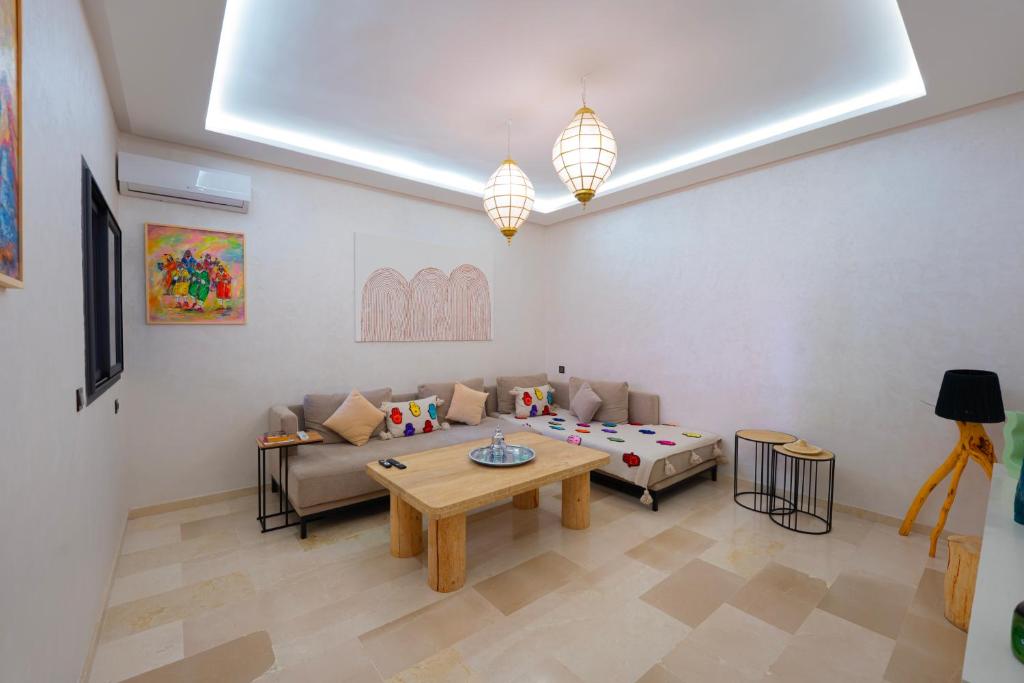 ein Wohnzimmer mit Sofa und Tisch in der Unterkunft Luxury Central Apartment Marrakech Pool Near train station in Marrakesch