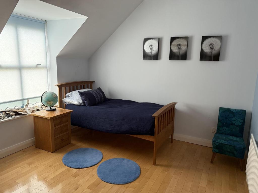 ein Schlafzimmer mit einem Bett, einem Stuhl und einem Fenster in der Unterkunft John's Seafront Apartment - B5 in Newcastle