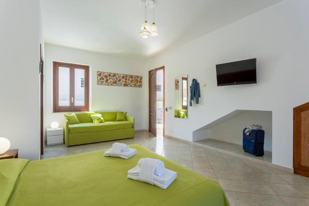 een slaapkamer met een groen bed en een groene bank bij Poseidon Residence in San Vito lo Capo
