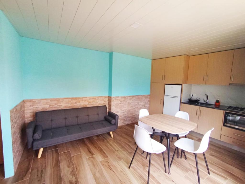 een woonkamer met een bank, een tafel en stoelen bij Studio Casa Miradouro Fafião in Fafião