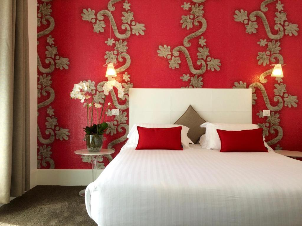 a bedroom with red walls and a bed with red pillows at Hotel Villa Rose in Nice