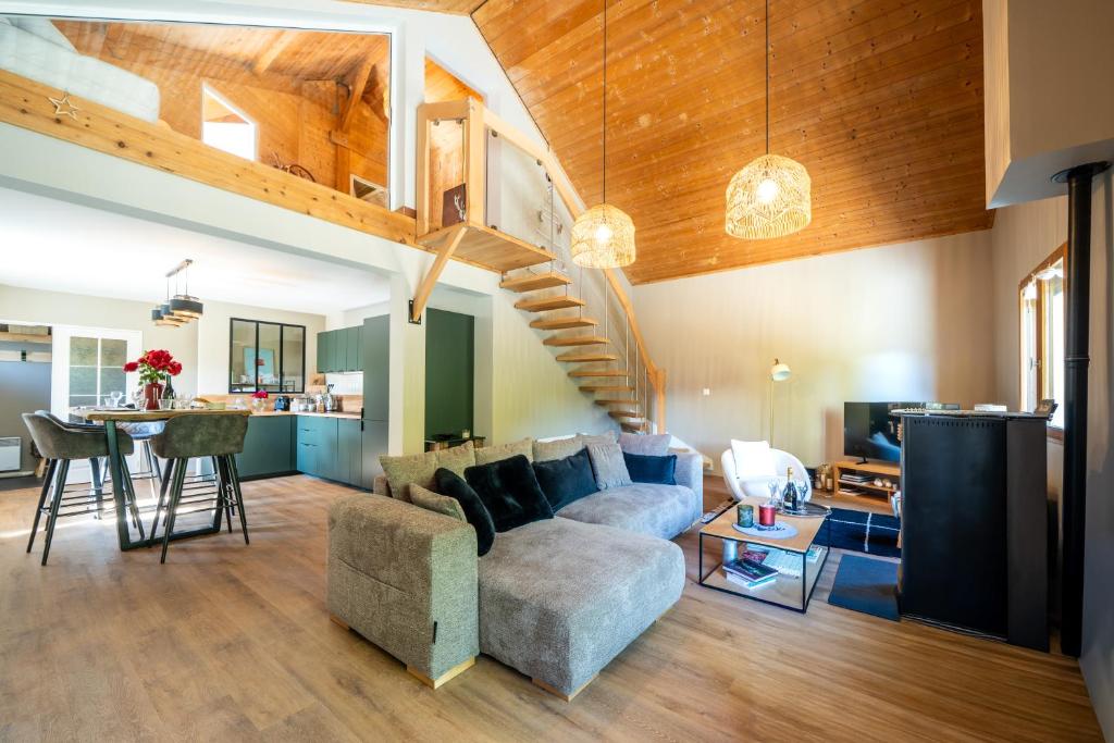 een woonkamer met een bank en een trap bij Chalet Le cocon plein sud in Saint-Chaffrey